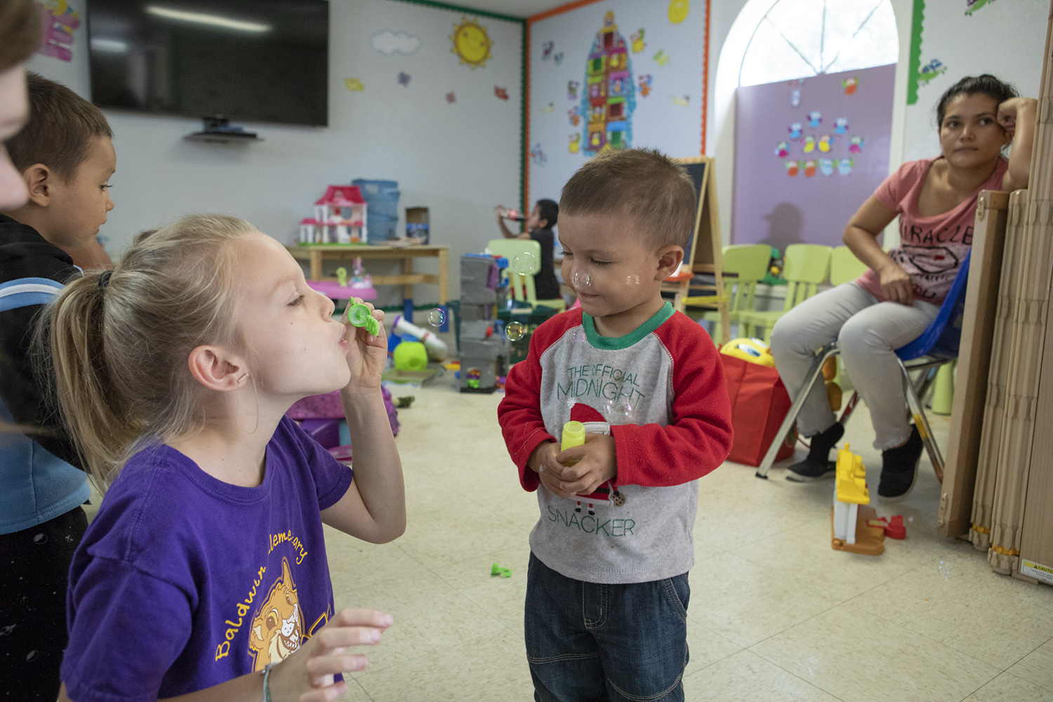 Kerlin, center, plays with another child as his mother Jasmira watches at the Catholic Charities shelter in McAllen on June 23, 2018.