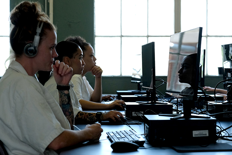 From left, Ginger Briggs, Phyllis Ochoa, and Kyrsten McCarthy work on computers to learn the technology needed to program and operate specialized wood and metal carving tools at the Hilltop Unit in Gatesville, Texas.