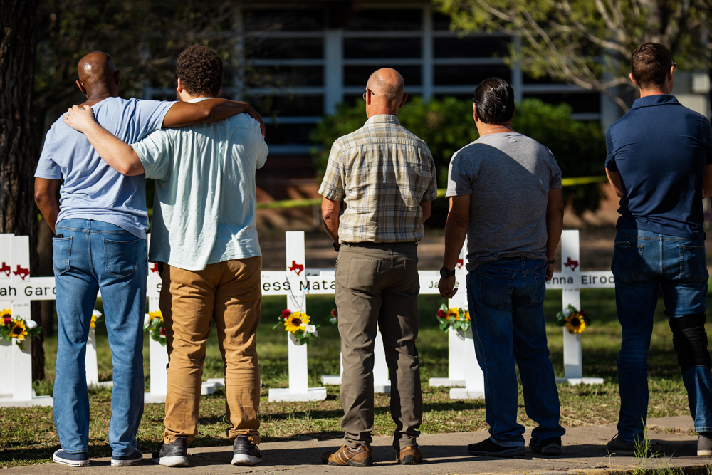 Mourners grieve Thursday in front of memorial crosses for the victims of the mass shooting at Robb Elementary School.
