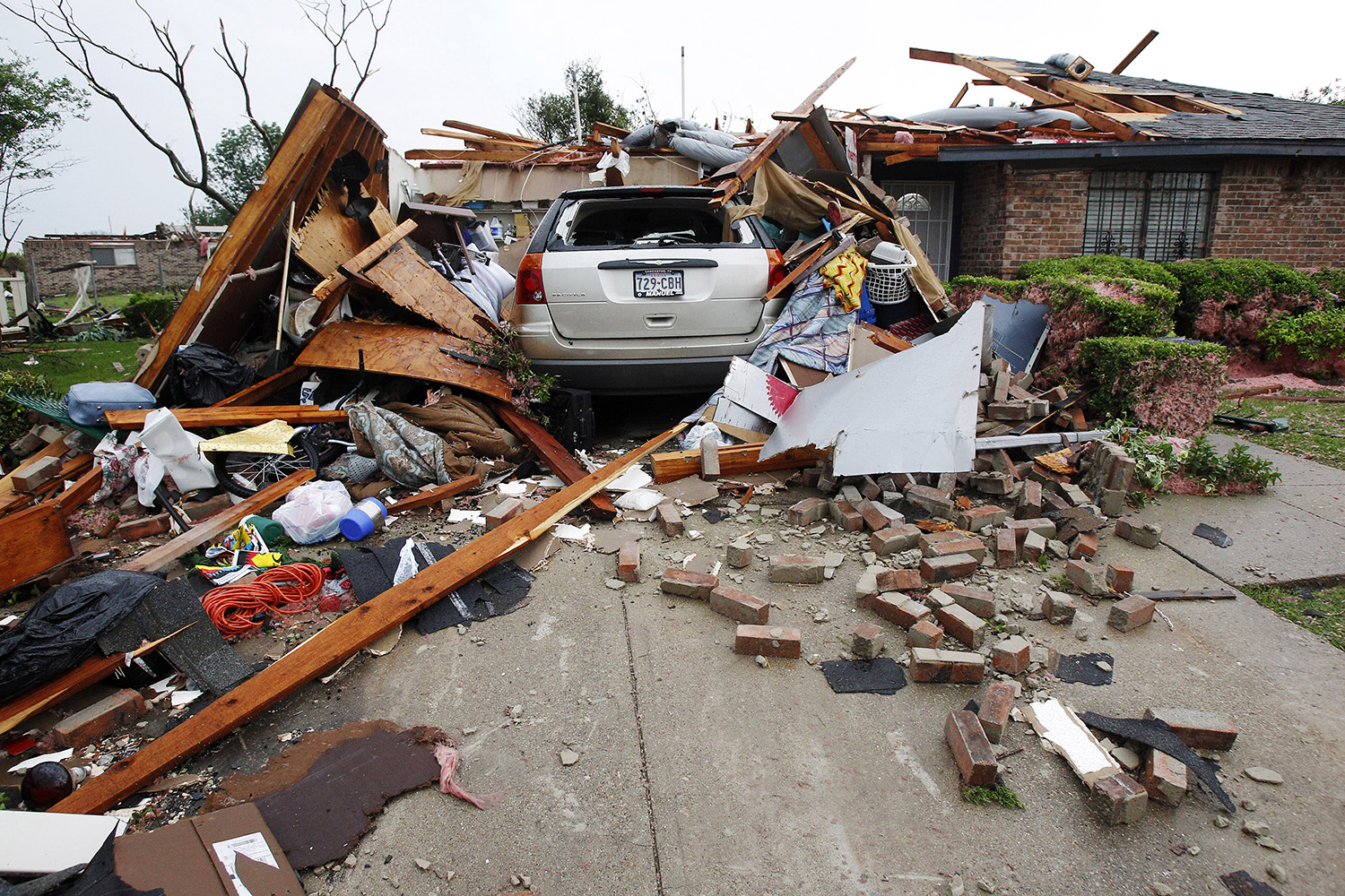 A vehicle rests in the driveway of a home destroyed by a series of tornadoes ripping through the Dallas suburb of Lancaster on April 3, 2012. Up to a dozen tornadoes skipped through the densely populated Dallas-Fort Worth area, ripping apart homes and tossing tractor-trailer trucks into the air, but there were no reports of serious injuries or deaths.