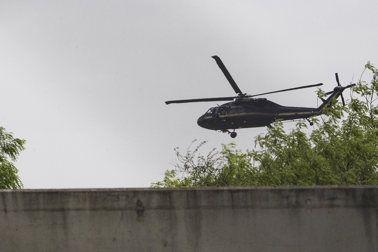 A Department of Homeland Security Blackhawk helicopter flying near Hidalgo, swoops low over the Rio Grande above the border wall built in 2008.