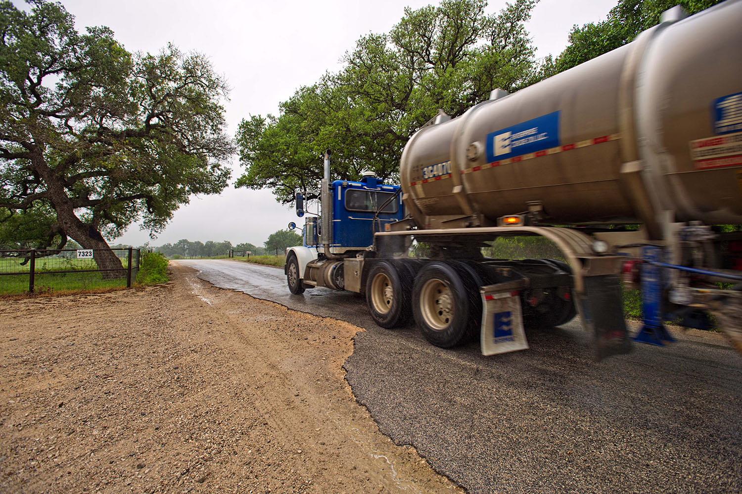 Trucks travel along the badly damaged FM 2067/ Cheapside Rd. near Cheapside on April 9, 2018