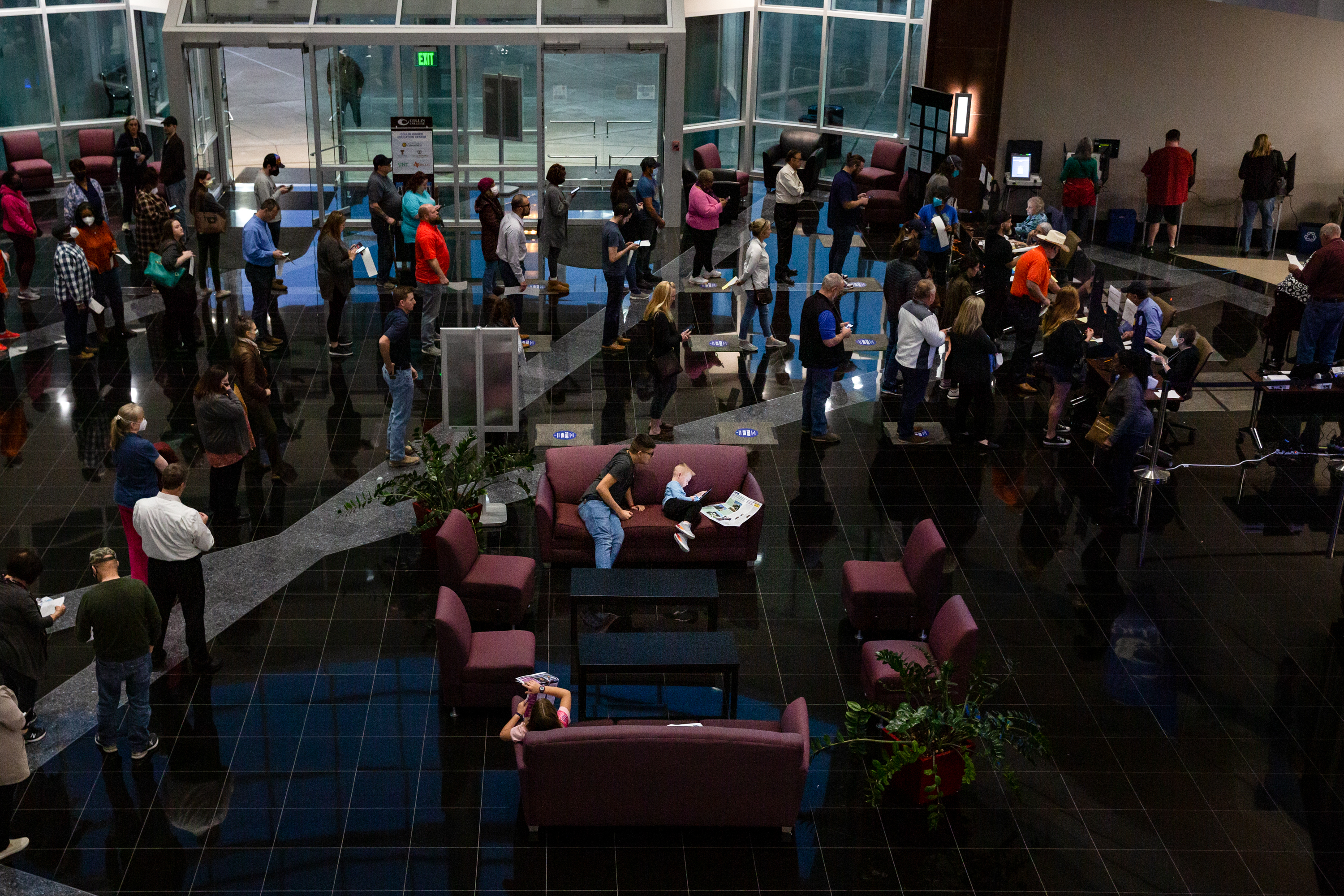 People wait in line to cast their votes in the primary election at Collin College in Mckinney on March 1, 2022.