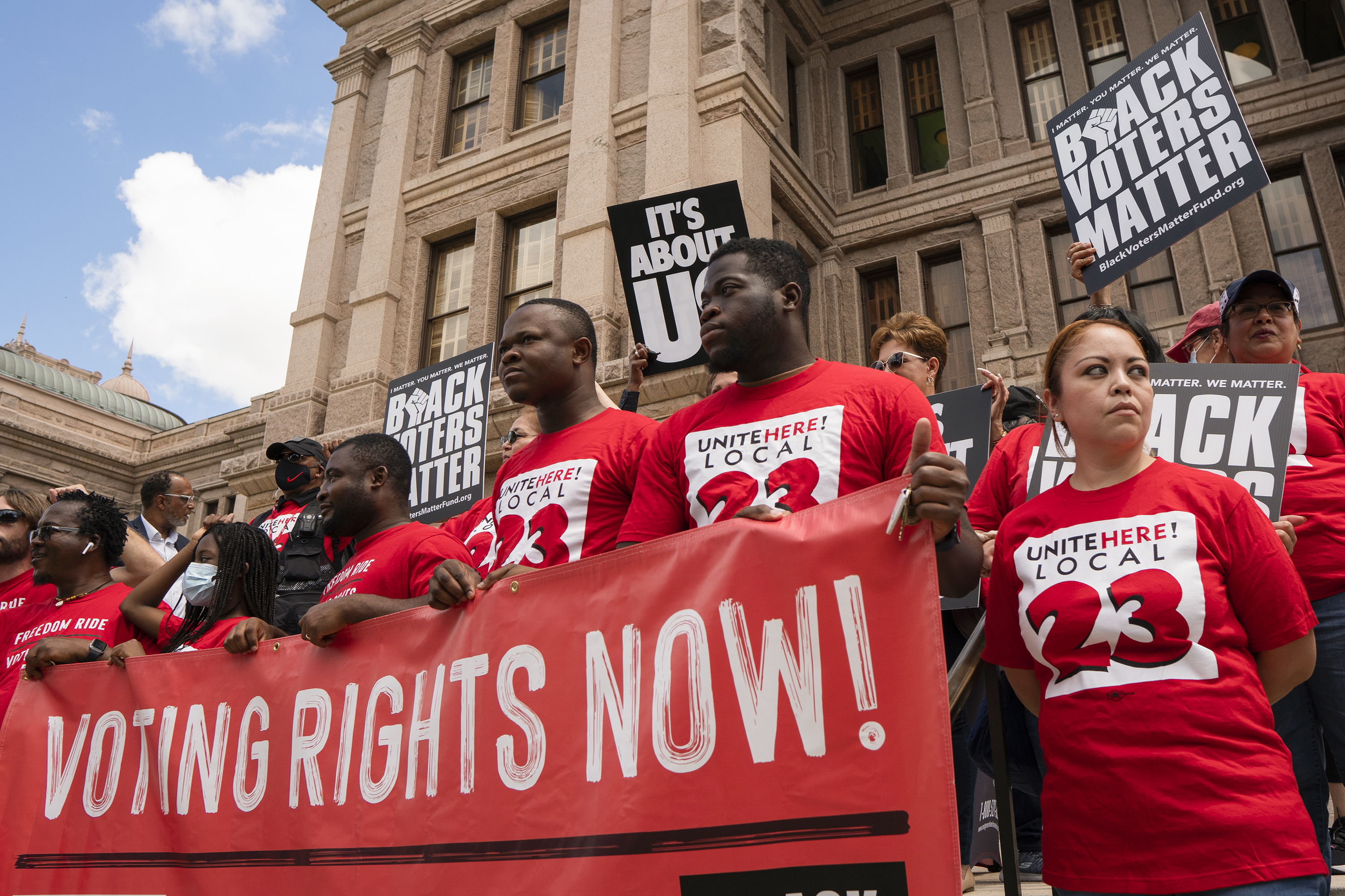 Individuals stand on the south steps of the Texas Capitol in support of voting rights at a press conference organized by Black Voters Matter, the Texas Right to Vote Coalition, Texas for All Coalition and other advocacy groups on July 8, 2021.