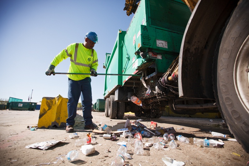 Glenn Bailey cleans out a city of Houston recycling truck on March 18.