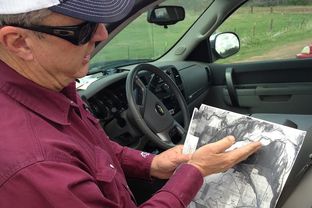 Tommy Henderson shows a survey of land along the Red River in North Texas.