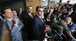 Gov. Rick Perry addresses the media following his court hearing on Nov. 6, 2014.  At far left is attorney Tony Buzbee.