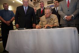 Gov. Greg Abbott signs an open-carry bill passed by the state Legislature at Red’s Indoor Range, a gun store and shooting range in Pflugerville, Texas, on June 13, 2015.
