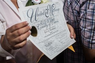 Pamela Holwerds holds up her marriage license following the ceremony that married over 40 same-sex couples on the south lawn of the Texas Capitol in Austin on July 4, 2015.