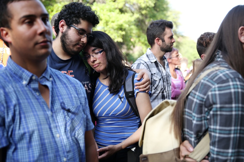 UT students Alfonso Galindo holds onto Erica Gomez during a community gathering in honor of Haruka Weiser on the University of Texas campus on April 7, 2016.