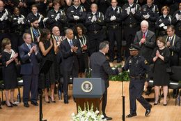 Dallas Mayor Mike Rawlings shakes Chief of Police David Brown's hand as former President Bush, President Obama, their wives, U.S. Sens. Cornyn and Cruz and others applaud on July 12, 2016.