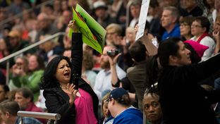 Attendees hold up signs in the bleachers at a town hall meeting in Flower Mound held by U.S. Rep. Michael Burgess, R-Lewisville on March 4, 2017.