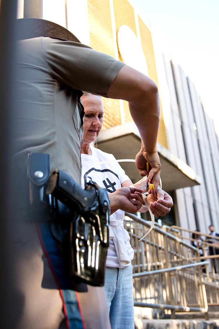 A Department of Public safety officer removes a zip tie from a protester's wrists in Austin on May 1, 2017. 