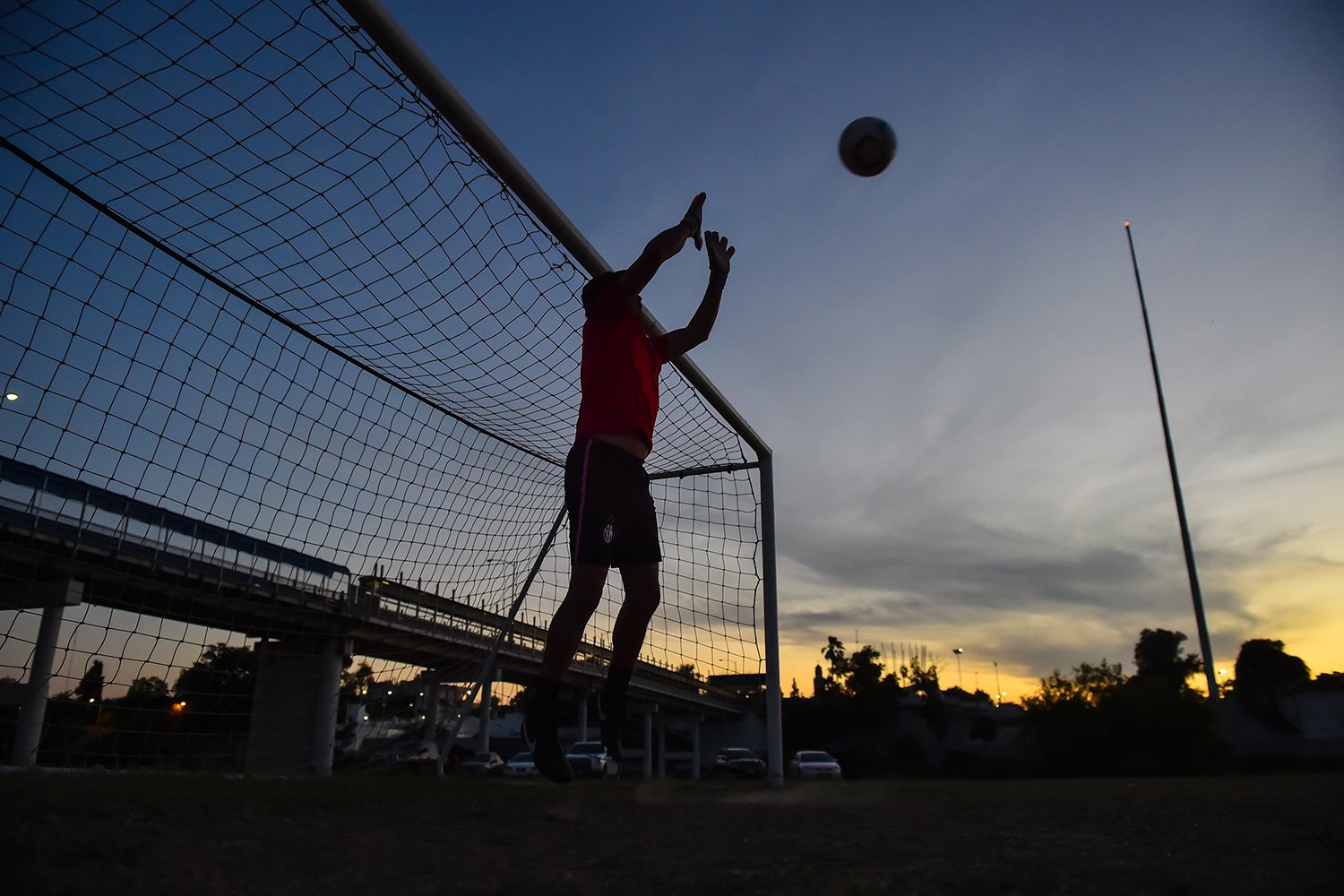 Members of the Twin Cities FC practice at twilight on an Eagle Pass soccer field between the Rio Grande and the current border fence. Piedras Negras, Mexico, is in the background.