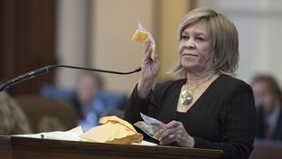 State Rep. Helen Giddings, D-Desoto, holds up a sample of a piece of cheese given to students who lack money to pay for school lunches in Dallas area schools during a personal privilege speech on the House floor May 9, 2017, where she chastised House Freedom Caucus members for killing her bill on school lunches for poor kids. 