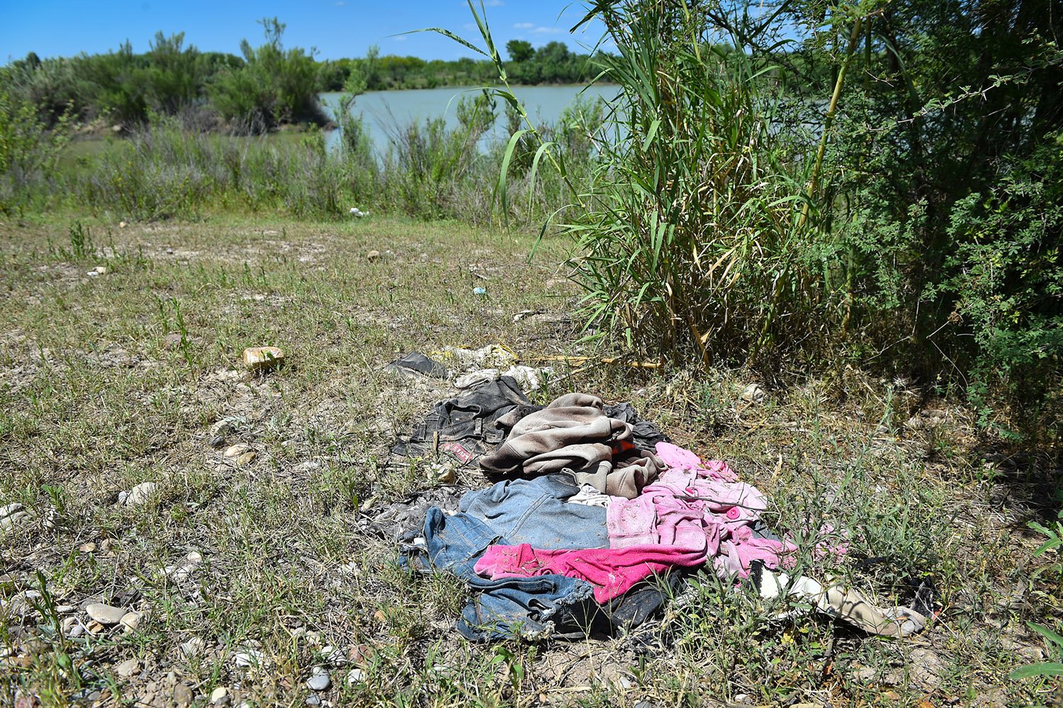 A pile of clothes near the river on Salvador Salinas's 500-acre ranch in Maverick County. Migrants often discard used clothing after making it to the north bank of the Rio Grande. 