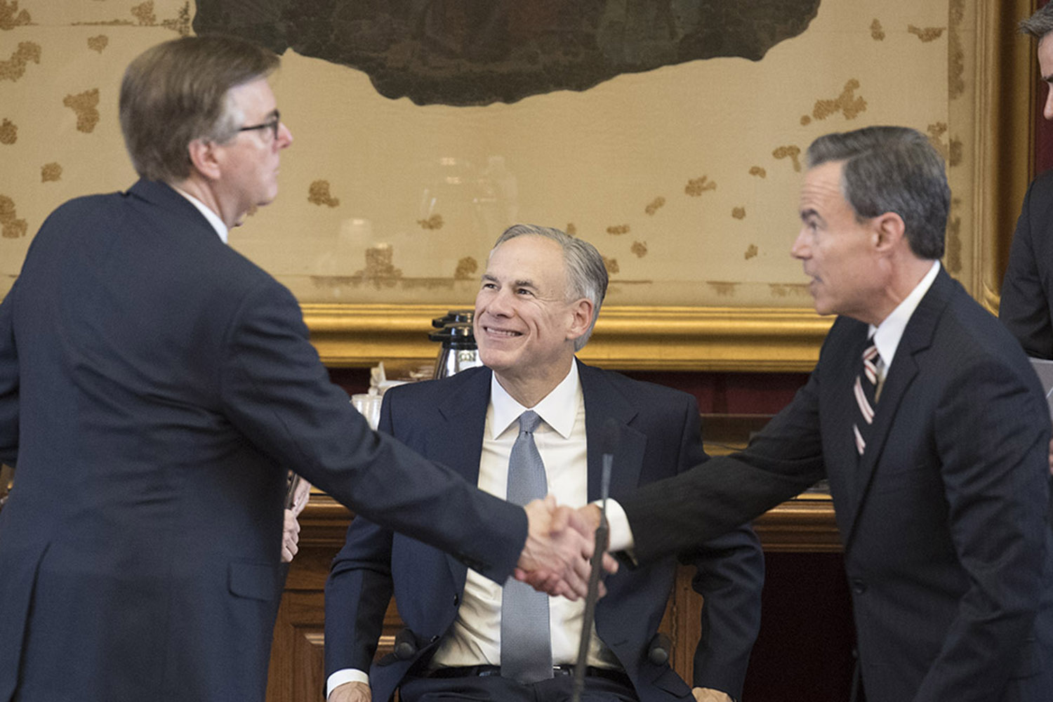 Gov. Greg Abbott looks on as Lt. Gov. Dan Patrick, left, and House Speaker Joe Straus shake hands on Saturday.