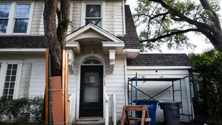 A tree is protected by wood planks during construction at a private residence in Austin on June 12, 2017.