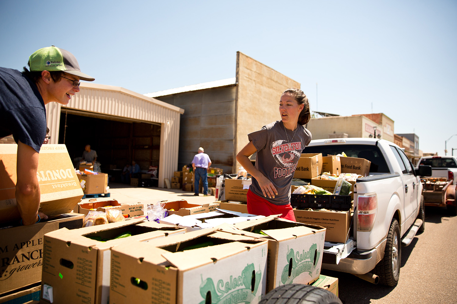 Sage Cabellero loads a family box onto a trailer for delivery to Silverton, Texas, a neighboring community in the Tri-County Meals network.