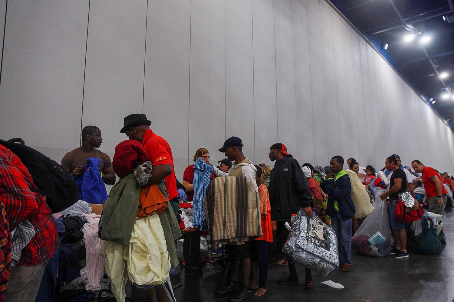 Evacuees seeking shelter from flooding wait in line to get into the George R. Brown Convention Center in Houston on Sunday, Aug. 27, 2017. 