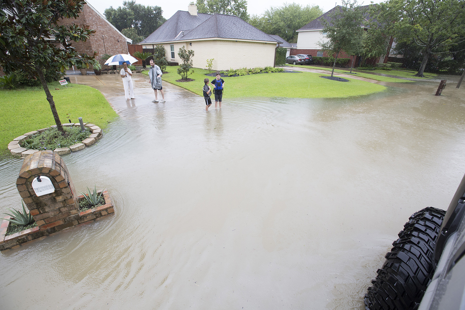 Chris Ginter, center, tries to convince a resident of a flooded neighborhood near Buffalo Bayou in Houston to evacuate in his monster truck on Tuesday, Aug. 29, 2017.