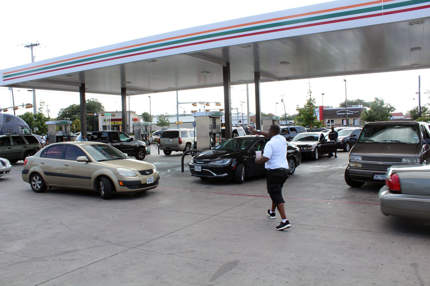 A 7-Eleven employee tries to keep order as cars in West Dallas stream toward gas pumps, trying to fill up amid a panic in Dallas-Fort Worth about rising prices and shortage of fuel in the wake of Hurricane Harvey's impact on oil production on Aug. 31,. 