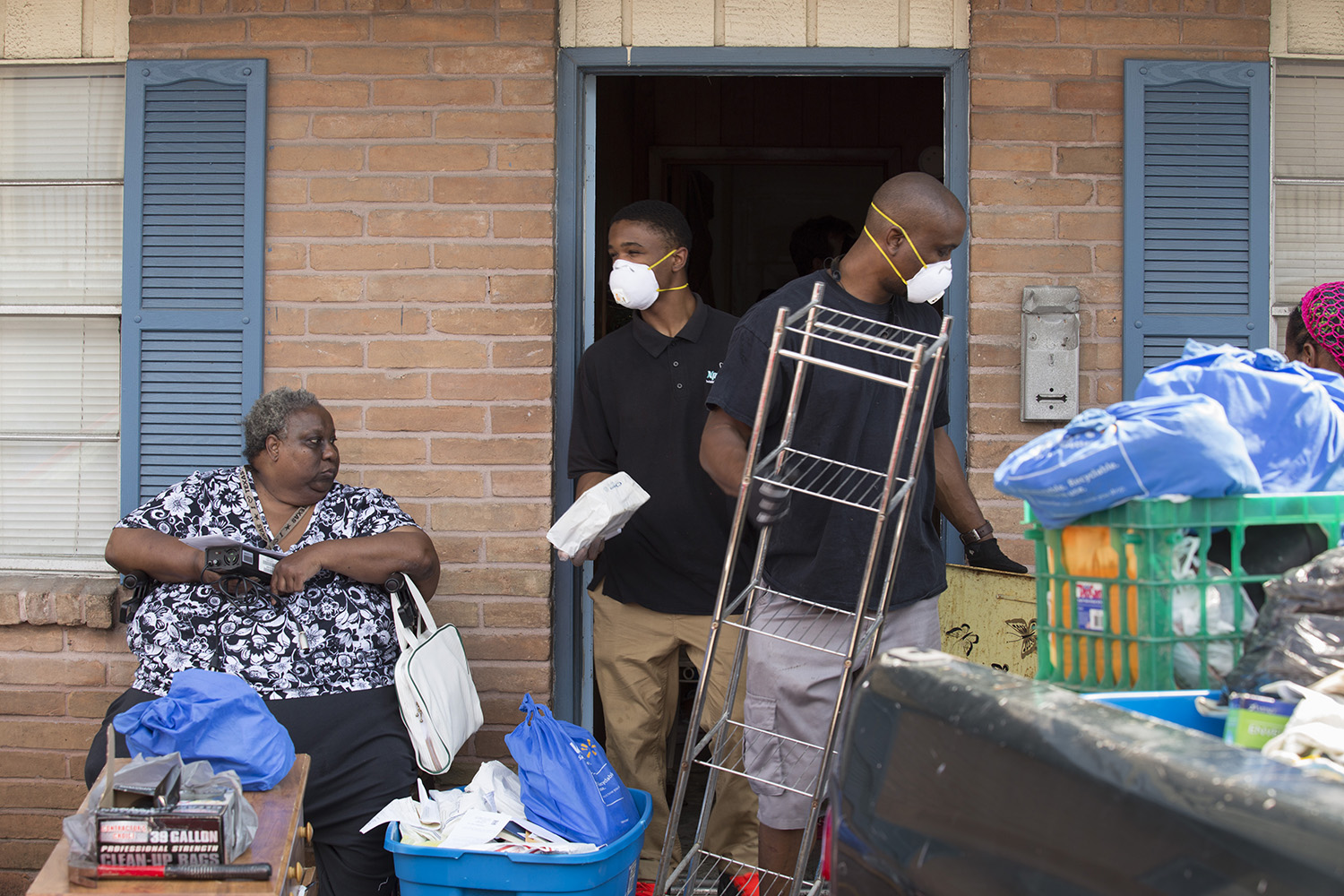 Marilyn Wilson, 61, watches as volunteers Jamal Stenson and his son Aahmad clean her flooded apartment out in the Kashmere Gardens neighborhood of Houston on Thursday, Aug. 31, 2017.