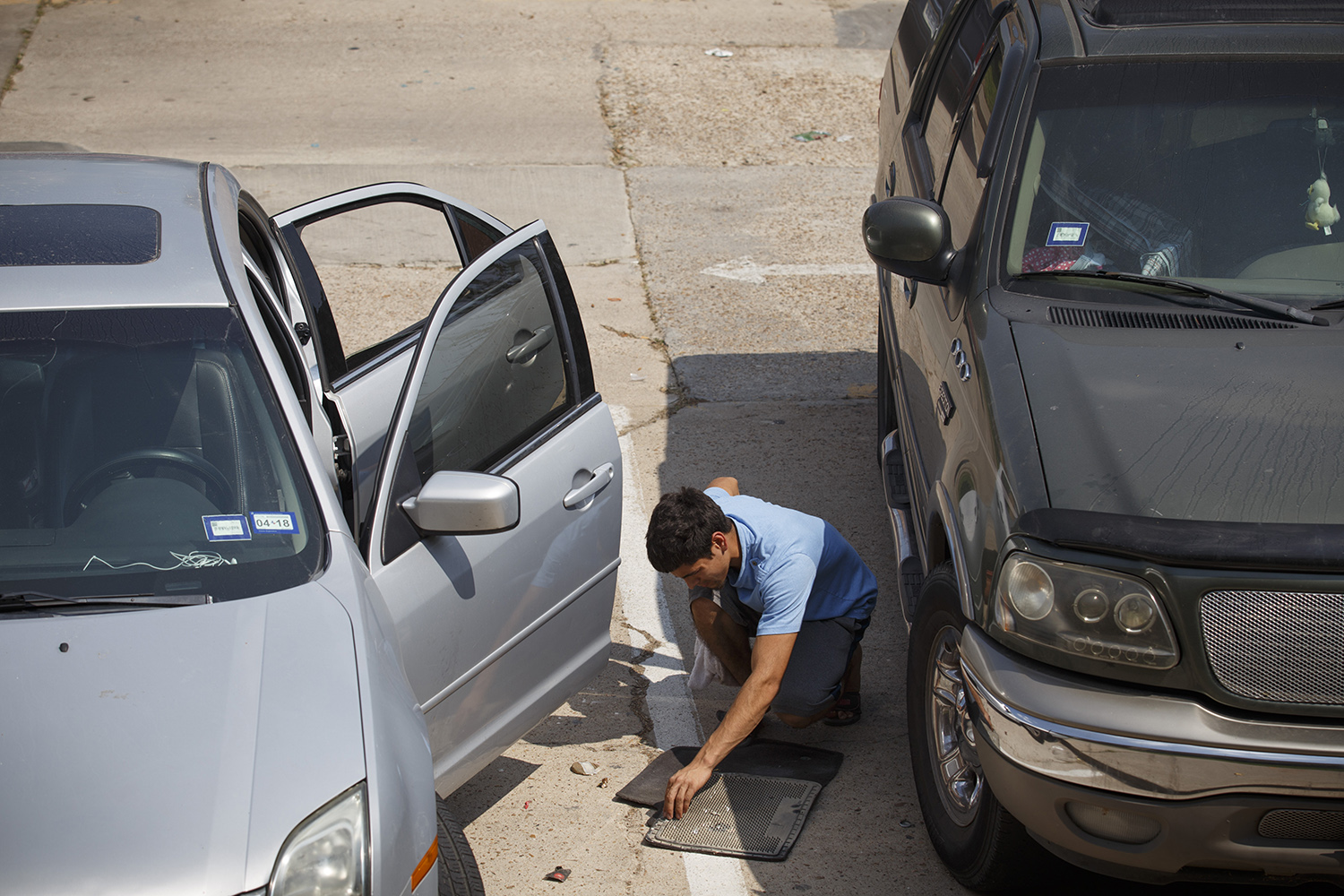 Daniel Gonzalez, who lives in an apartment in the Greenspoint area of Houston, cleans a floor mat from his flooded car on Sept. 14, 2017.