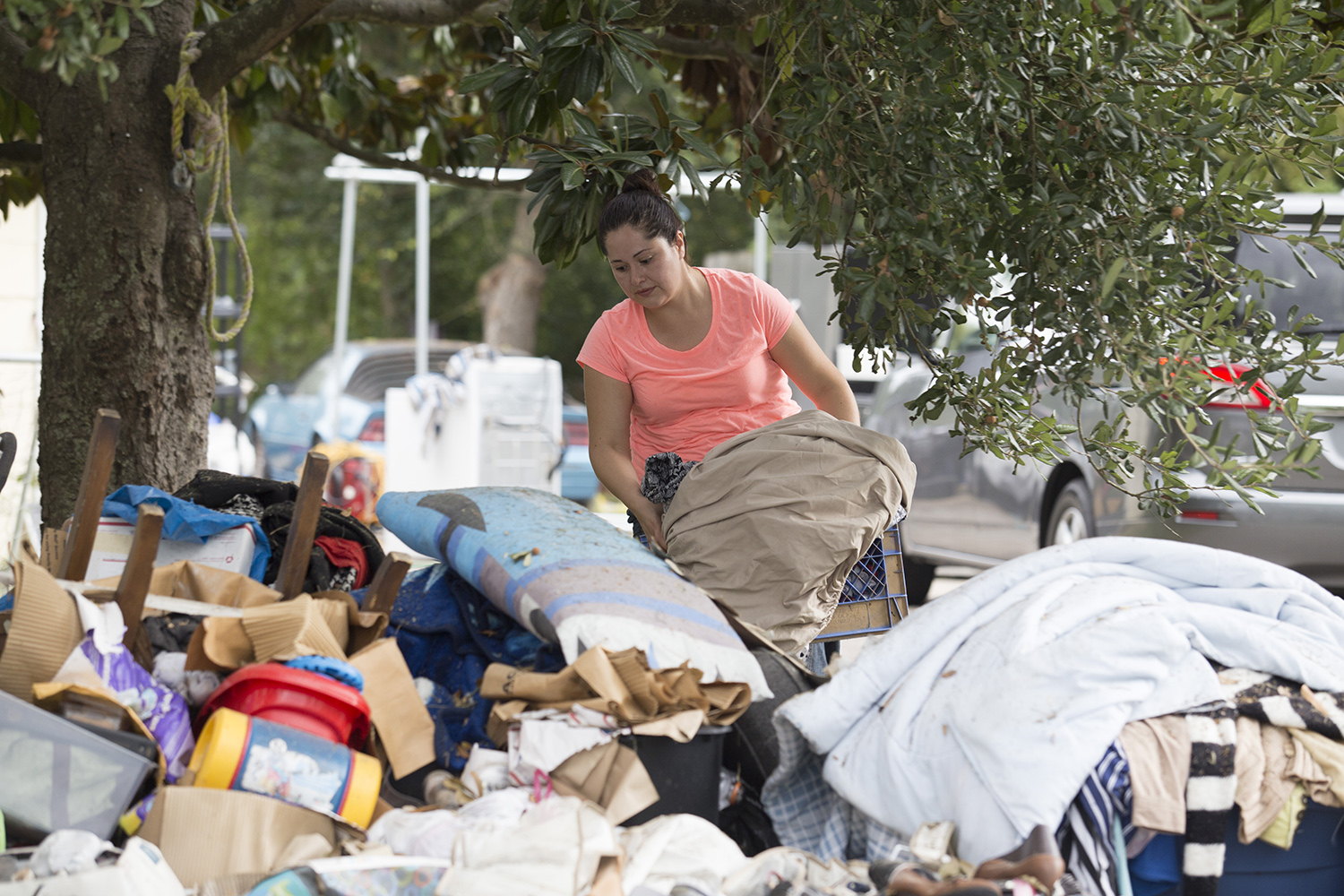 Guadalupe Carrillo sorts through flood damaged items at her home in Port Arthur, Texas.