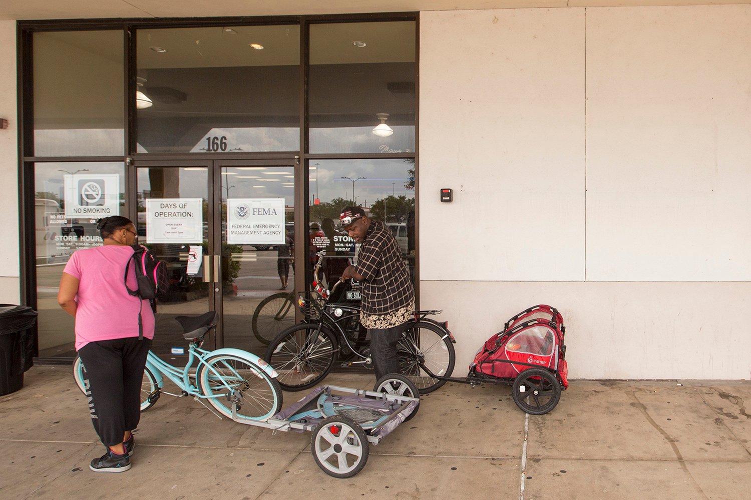 Crystal and Ollie Green rode their bikes to the Beaumont disaster recovery center, where they are seeking help after their apartment flooded.  