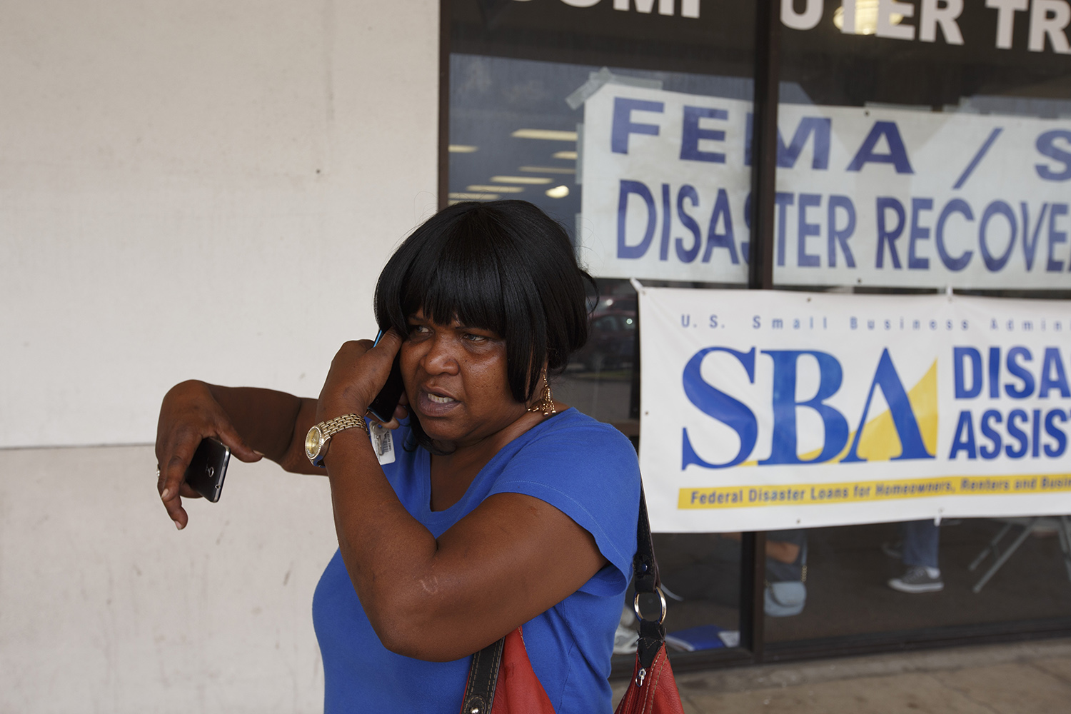 Veda Armstead takes a phone call outside of a Beaumont disaster recovery center. Armstead said she was able to save some clothing from her flooded house — a few items that were hanging or on higher shelves — but that everything else was “wiped out.” She’s currently moving between the homes of friends and relatives while she figures out whether she’ll be able to make repairs on her home.