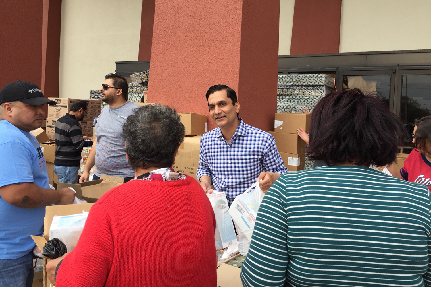 Health care executive and congressional candidate Tahir Javed hands out food in Pasadena on Saturday, March 3, 2018. 