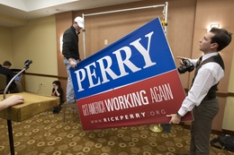 Perry campaign workers take down the final sign of Perry's presidential campaign at the Hyatt Place Hotel where he announced the suspension of his campaign on January 19, 2012.