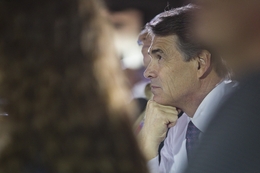 Gov. Rick Perry listens to U.S. Rep. Michele Bachmann's speech at an event in Waterloo, Iowa, on Aug. 14, 2011.