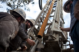 Workers with Bee Cave Drilling install a jackhammer bit on the drilling rig while putting in a water well on a private lot in Spicewood, Texas on February 6, 2012.