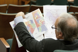 State Sen. Kirk Watson, D-Austin, looks at redistricting maps at a Senate hearing on May 13, 2011.