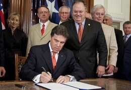 Gov. Rick Perry ceremonially signs Senate Bill 18, a piece of eminent domain legislation, on May 23, 2011, beside state Sen. Craig Estes, R-Wichita Falls, and Rep. Charlie Geren, R-River Oaks.